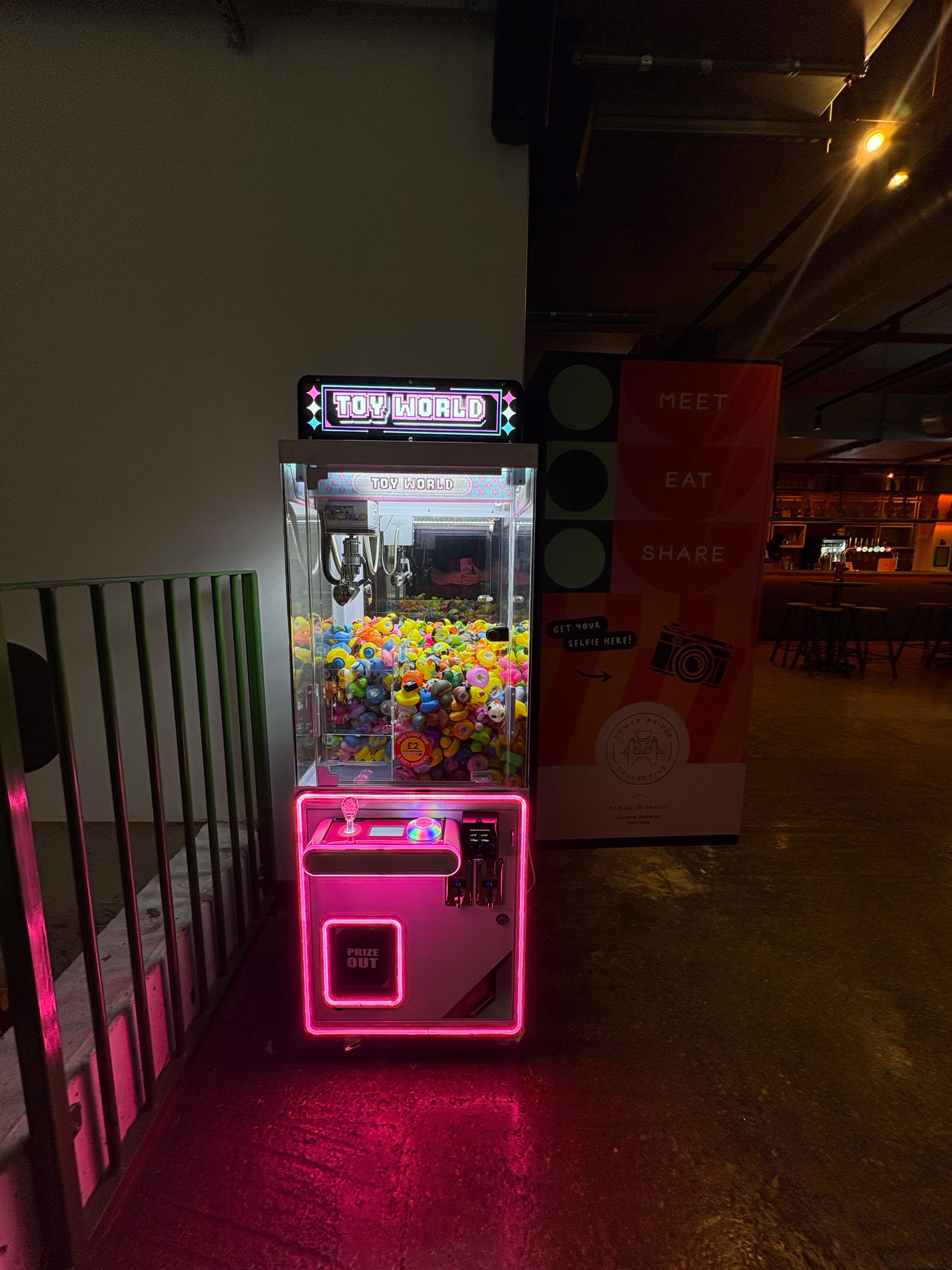 A Toy World claw machine at the entrance of a bar